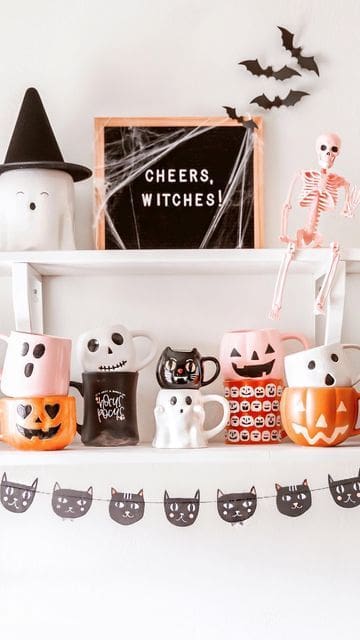 Halloween coffee mugs stacked on floating shelves in kitchen