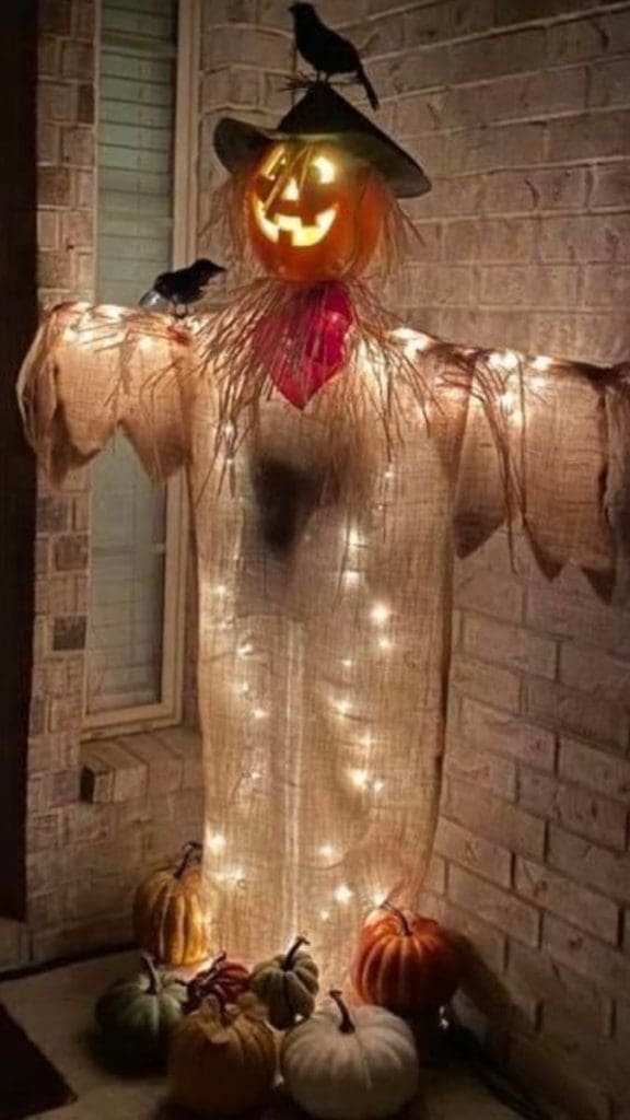 light up halloween decoration of pumpkin scarecrow on front porch