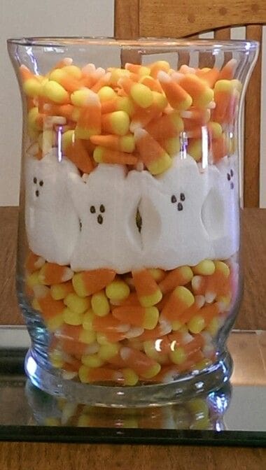 a jar full of candy corn for Thanksgiving on an office desk