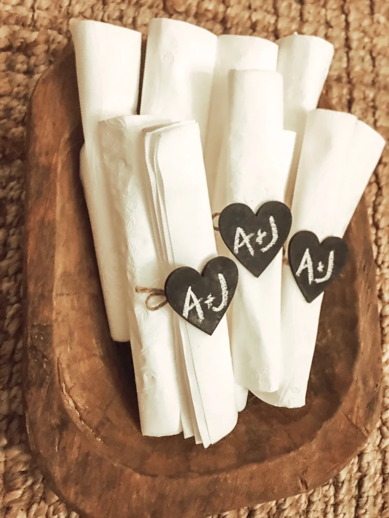 White napkins tied with heart-shaped chalkboard place cards