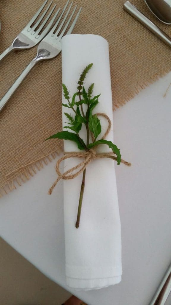 White napkin tied with twine with herb sprig