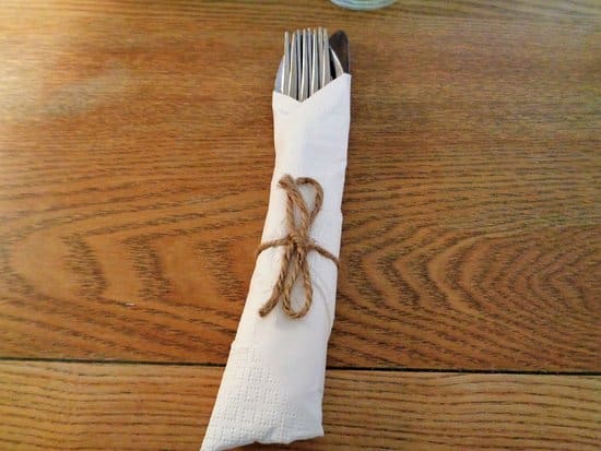 cutlery wrapped in white napkin with twine