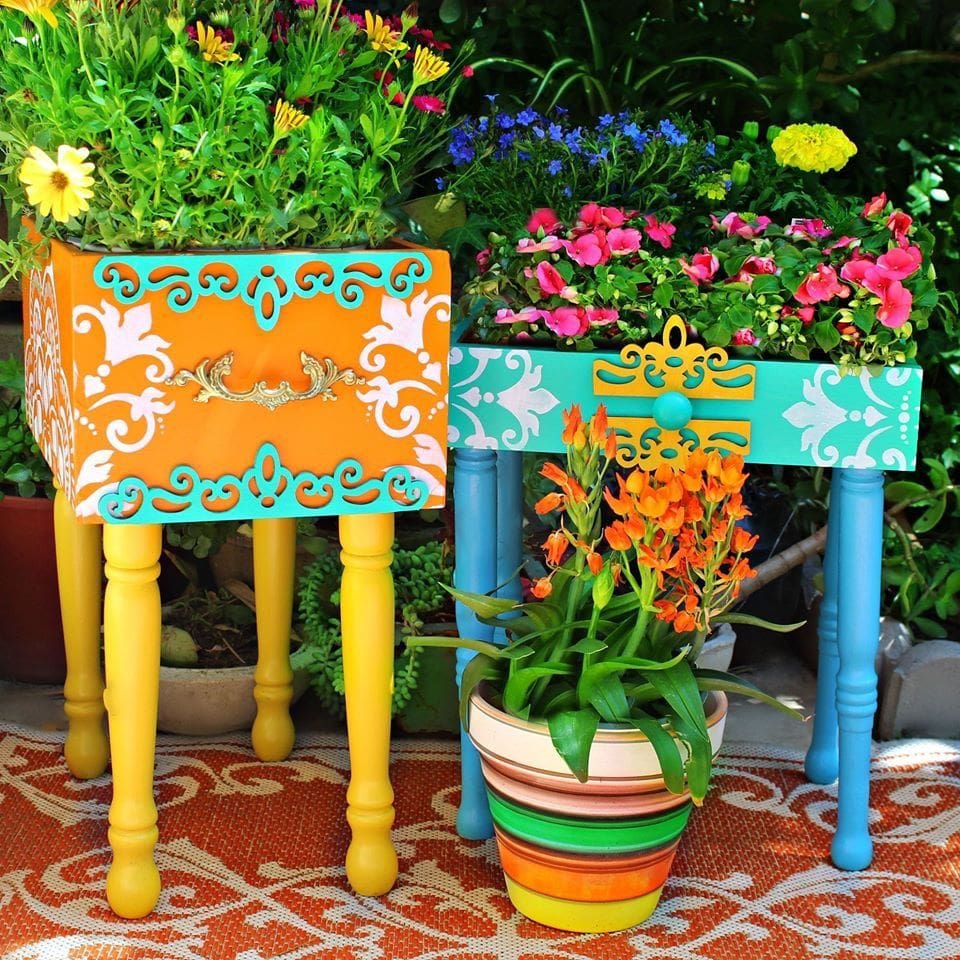 Colourfully painted drawers used as planters for flowers