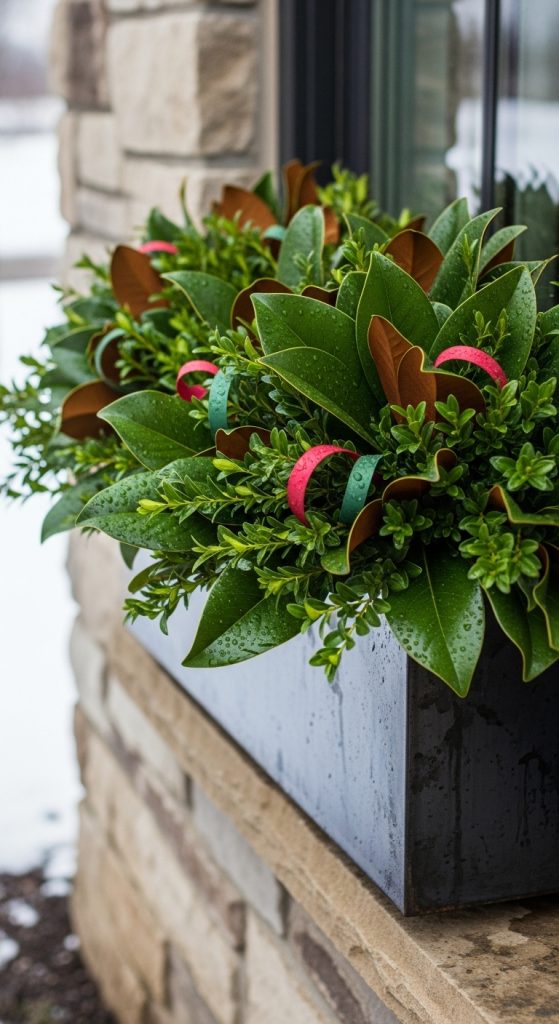 Boxwood and magnolia leaves in a modern black winter planter box 