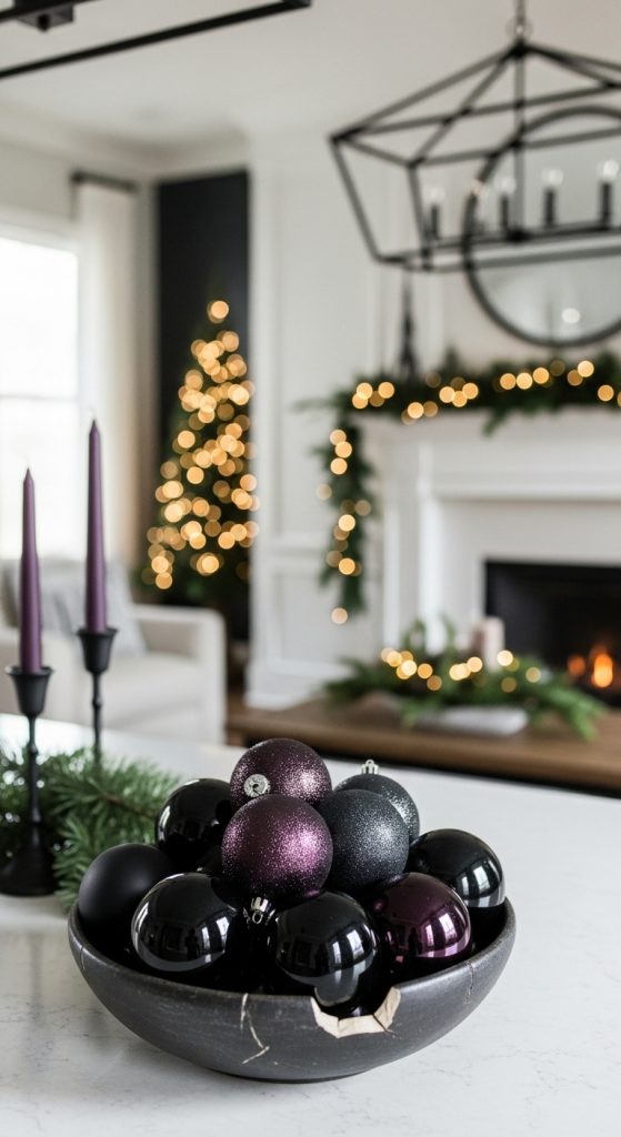 Black and plum colored ornaments in a black chipped bowl on a kitchen island