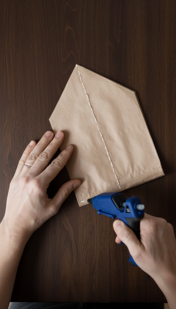 hot glue gun being used on the brown paper star