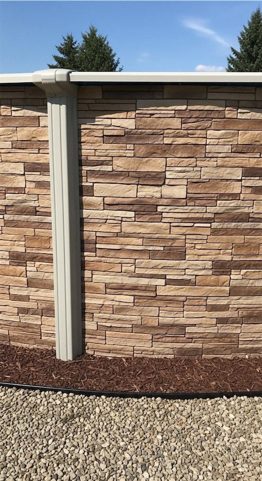 Stone faux panels on the outside of the pool